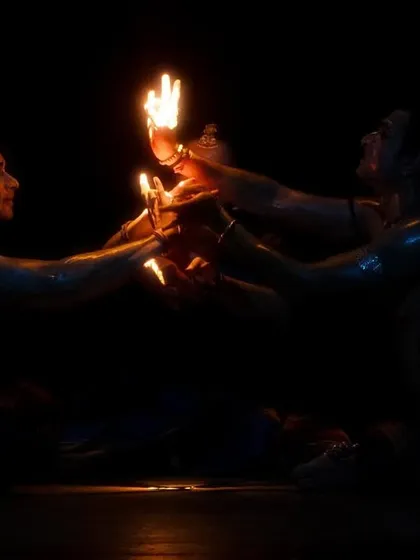 A close-up of the artists' hands holding lamps in 'Nagamandala', a simple yet powerful image.