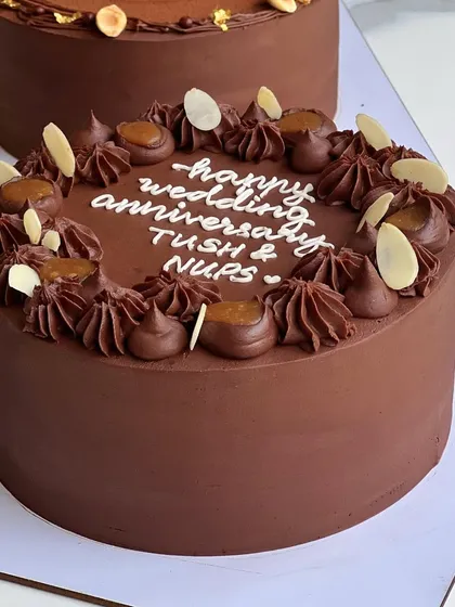 My Chocolate Salted Caramel cake, decorated with chocolate swirls, caramel pieces, and toasted almonds. It's a sophisticated and delicious choice for any celebration.