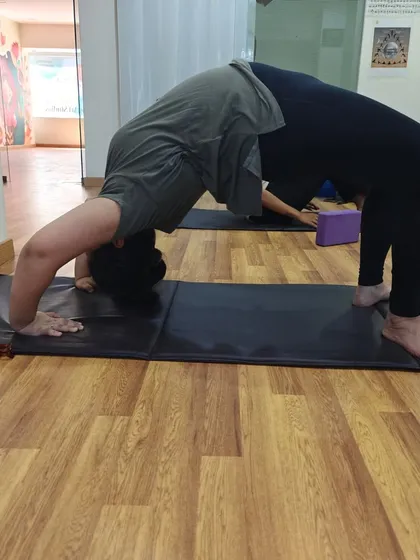 A student works on their Chakrasana on the mat. Consistent practice builds the strength and confidence needed for deep backbends like this one.