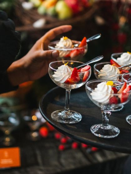A server presents a tray of our strawberry and cream desserts. This shows our attentive service style, ensuring guests can easily enjoy the offerings from the grazing table.