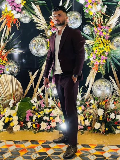 Posing against a festive backdrop, perfect for a sangeet or reception. I bring a professional yet fun presence to your wedding events.