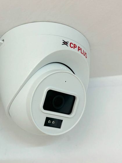 A CP Plus dome camera installed neatly in the corner of a room. This placement provides a wide viewing angle to cover the entire space effectively.