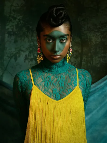 This image is from a creative collaboration, focusing on color theory and avant-garde makeup. The composition and the model's direct gaze are meant to be confrontational and beautiful, celebrating bold, artistic expression in fashion.