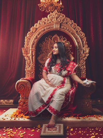 Embodying the spirit of the goddess, this mother-to-be exudes strength and grace, a true reflection of Durga in a regal setting.