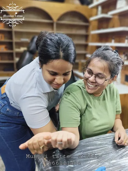 A friend admiring her bestie's new tattoo. The joy and excitement in these moments are what make our job so rewarding.