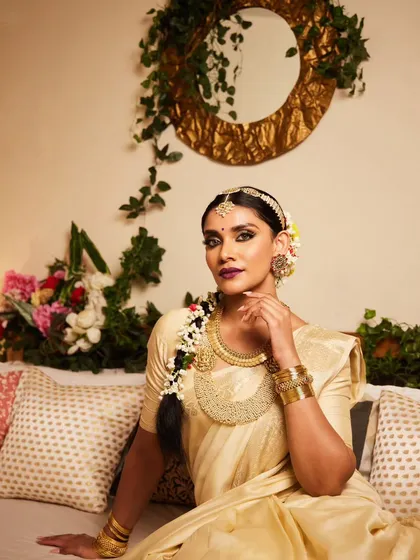 A full view of a traditional South Indian bridal hairstyle. The long braid is adorned with flowers and traditional hair jewelry, creating a look that is rich in culture and incredibly beautiful.