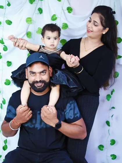 A fun family pose with the daughter sitting on her father's shoulders.