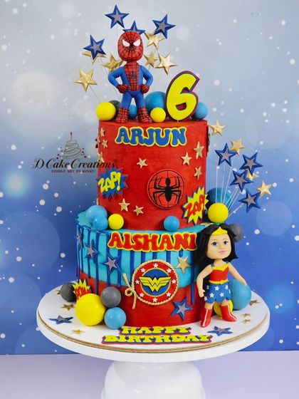 A full view of the vibrant red and blue superhero cake, decorated with stars and action words like "ZAP!" for a dynamic effect.