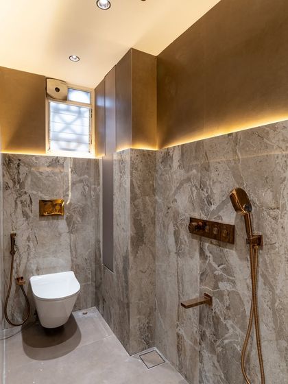 When luxury is written in every line and every light. This stunning half-and-half bathroom design balances rich brown tones with the timeless beauty of marble and the subtle elegance of matte-finish tiles, all highlighted by rose gold fittings.
