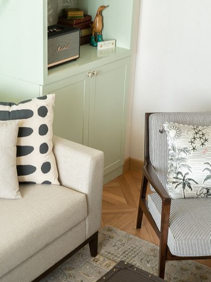 This inviting corner proves that comfort does not have to compromise on style. The mix of patterns on the cushions and the soft green cabinetry create a calming atmosphere perfect for unwinding.