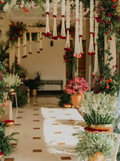 A beautiful floral entrance for a Mamera ceremony, using a vibrant palette of reds and oranges. The decor creates a warm and welcoming atmosphere for this important family ritual.