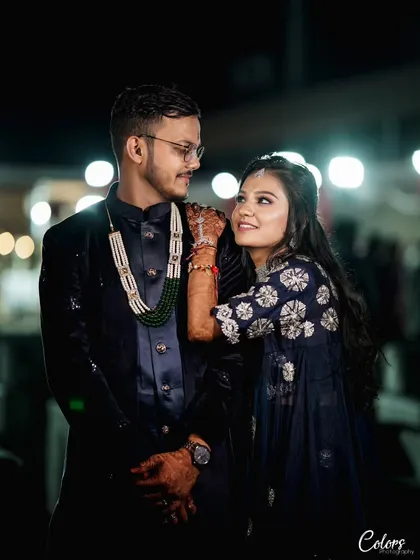 A stylish portrait of the couple at their Sangeet, with the bride resting her arm on the groom's shoulder.