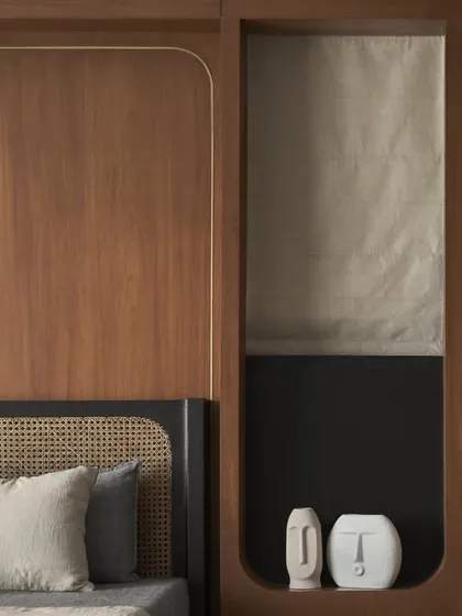 This detail shows the built-in niche next to the bed, a clever use of space that adds character and a place for personal decor. The wood panelling continues the room's warm, enveloping feel.
