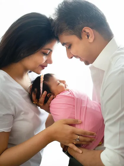 A backlit portrait that creates a soft, angelic glow around the new family. This is a beautiful artistic style for newborn family photos.