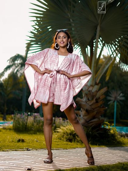 A confident, hands-on-hips pose from our resort wear shoot, with a palm tree framing the model perfectly.