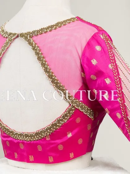 A closer look at the craftsmanship of this pink pure silk blouse. It features intricate handwork with bead detailing on the neckline and delicate net sleeves with linear embroidery for a touch of grace.
