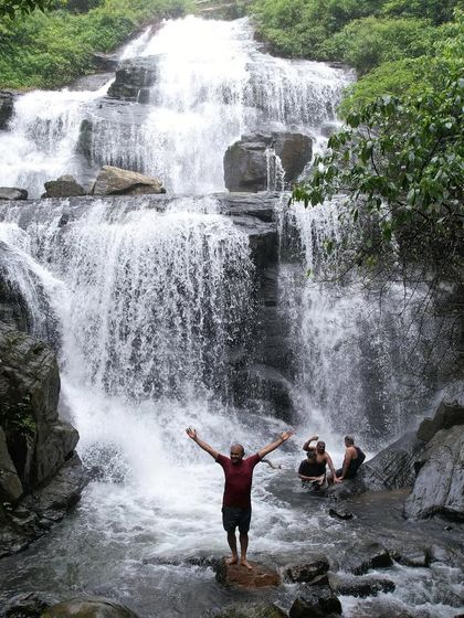 Pure bliss! A trekker enjoying the cool, refreshing water at the base of a cascading waterfall. These are the moments of connection with nature that we seek.