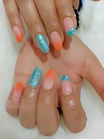 Another view of the bright orange ombre and turquoise glitter nail set.