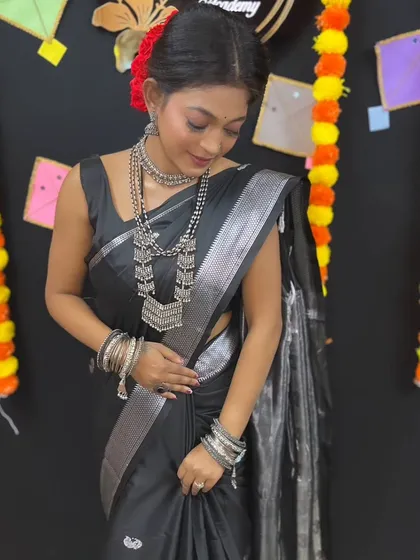 A graceful pose, highlighting the flow of the saree and the intricate details of the jewelry.
