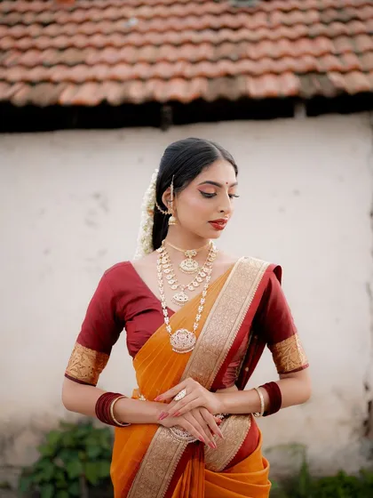 A serene portrait of a model in a traditional saree. The focus is on her calm expression and the beautiful details of her attire and jewelry.