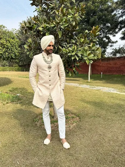 This shot captures the complete regal look of the Sikh groom, from the perfectly tied turban to the traditional juttis, embodying timeless elegance.