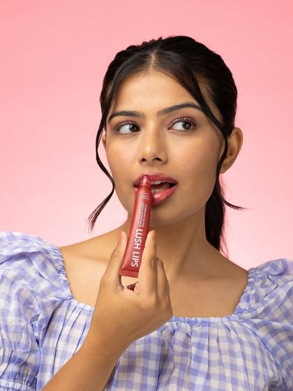 A candid, playful moment of application. This image feels authentic and unstaged, helping to build a connection with customers who are looking for beauty products that fit into their real lives.