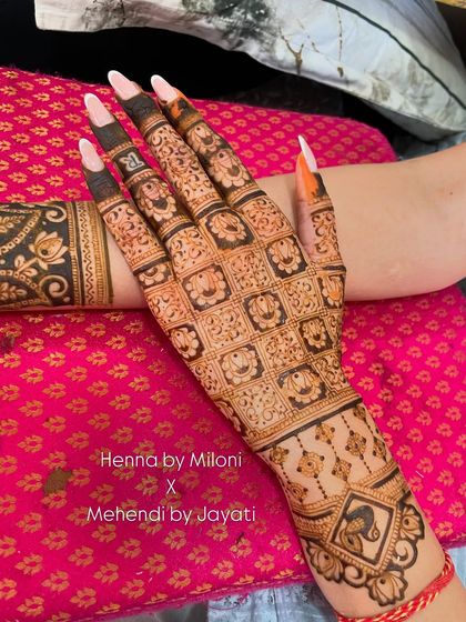 A detailed close-up of a hand with intricate grid work and floral patterns.
