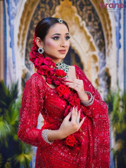 This image displays the full length of the rose-adorned braid, a key element of this traditional bridal hairstyle.