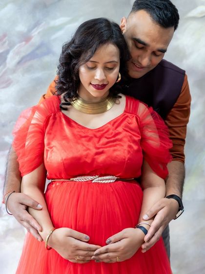 A tender moment between a couple, with the dad-to-be gently holding the baby bump in our studio.