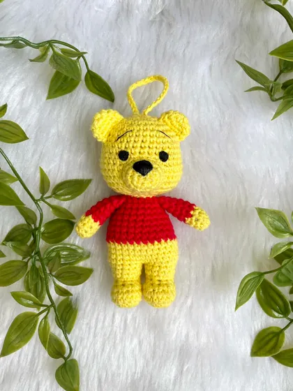 A sweet Winnie the Pooh keychain. This classic character is perfect as a small, adorable accessory to hang on a bag or keys, bringing a little bit of the Hundred Acre Wood with you.