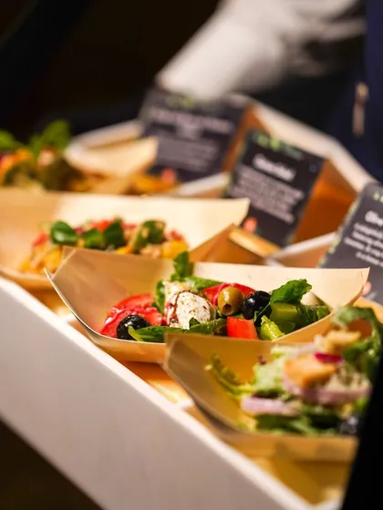 A variety of fresh salads served in individual, eco-friendly wooden boats for easy mingling.