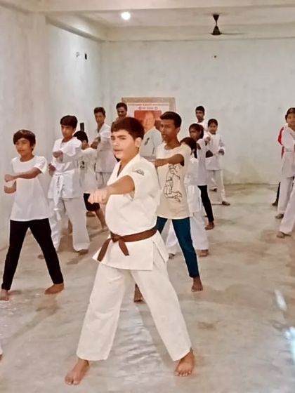 Students practicing a basic block in zenkutsu-dachi. Notice the focus on their faces. The white gi (uniform) and colored belts are our identity.