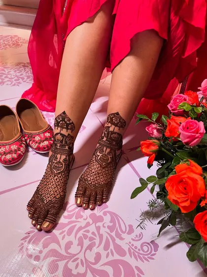 A classic foot design featuring a central motif with detailed jaali work, perfectly paired with traditional juttis for a complete ethnic look.