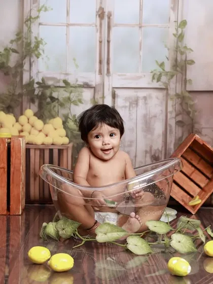 This little one is all smiles in a clear tub surrounded by fresh lemons and green leaves. It's a zesty, fun, and completely unique photo opportunity.