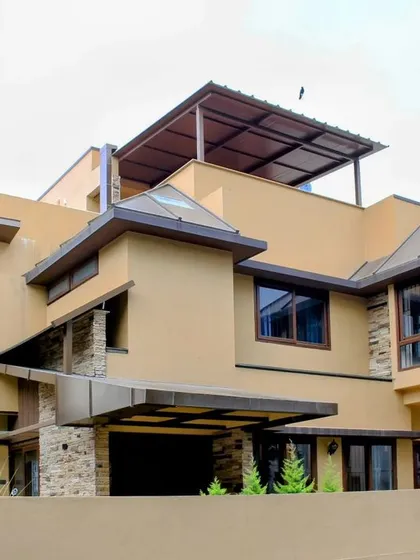 This perspective shows the layered composition of the building, with its multiple rooflines and the rooftop terrace, offering a blend of enclosed and open spaces.