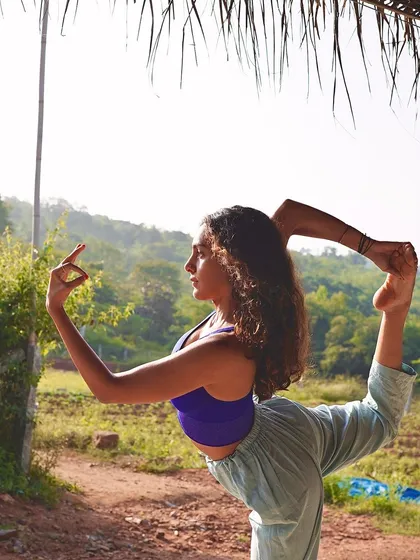 Holding Natarajasana (Dancer's Pose) in a natural, rustic setting. This pose embodies grace and strength, reflecting the balance we seek to find both on and off the mat.