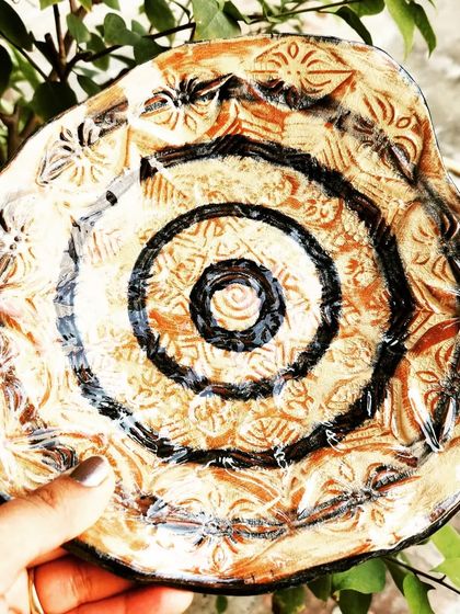 A handmade platter fresh out of the kiln. This piece was decorated using the Obvara firing technique, which creates a unique, rustic, and textured surface.
