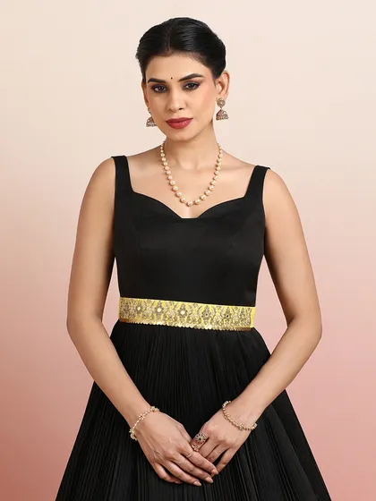 A close-up of the black gown's bodice, featuring a sweetheart neckline and a beautifully embellished golden belt.