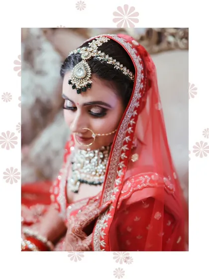 A close up portrait of the bride, with a focus on her intricate matha patti and the soft, smokey eye makeup.