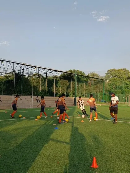 A group of players listening intently as their coach explains the next drill. Learning to play football starts with listening and understanding.