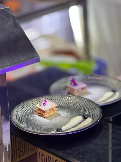 A delicate mille-feuille, dusted with powdered sugar and accented with blueberry coulis. This is where luxury lies in restraint and indulgence is the aftertaste.