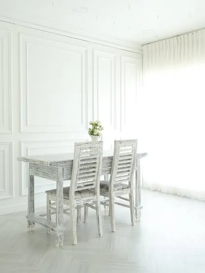 This is the heart of my studio: an all-white, elegant space filled with natural light. The paneled walls, distressed furniture, and sheer curtains create a perfect canvas for everything from classic portraits and lookbooks to clean product photography.