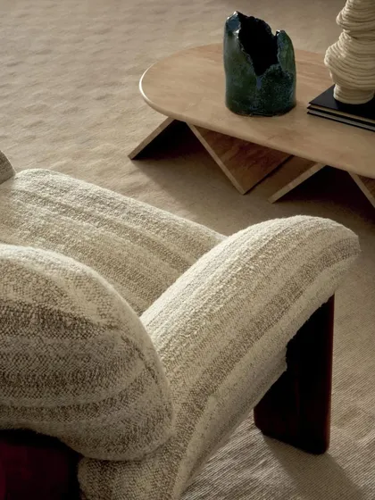 This armchair from the 'Prestige II' collection by Élitis is upholstered in a fabric with a flowing weave of undulating yarns. The design exudes graceful movement and captures the subtle beauty of natural elegance.
