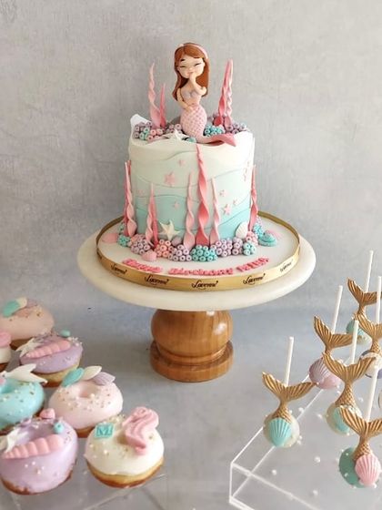 An underwater fantasy with this mermaid-themed dessert table. The cake is the star, but the mermaid tail cake pops and seashell donuts complete the magical scene.