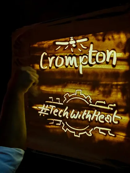 Performing live is where the magic truly happens. Here I am on stage creating a sand art story for Crompton during a corporate event. Seeing the company's logo and their story come to life in sand in front of a live audience, and receiving a standing ovation, is a testament to the impact of this art form in a corporate setting.