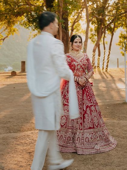 A creative shot capturing the groom in motion as he walks past his bride, who stands serene and beautiful in the golden light.