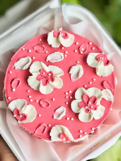 Mini but make it dreamy. This pink bento cake is adorned with fluffy buttercream florals and petals, perfect for a small, sweet, and pretty celebration.