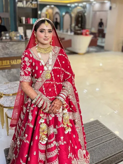 A full-length view of this stunning bride in her red lehenga. The makeup is soft and romantic, with a focus on glowing skin and subtly defined eyes.