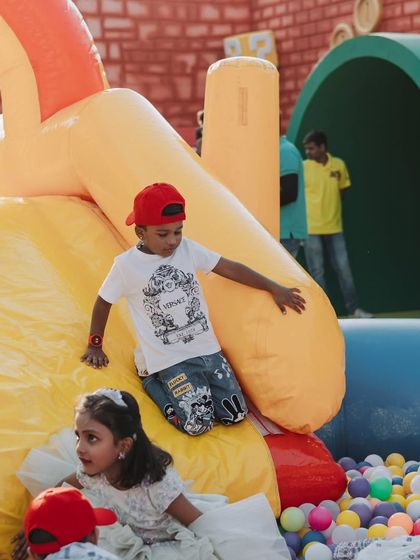Kids enjoying a large inflatable slide and ball pit. Providing a variety of fun and safe play areas is essential for a successful children's party.
