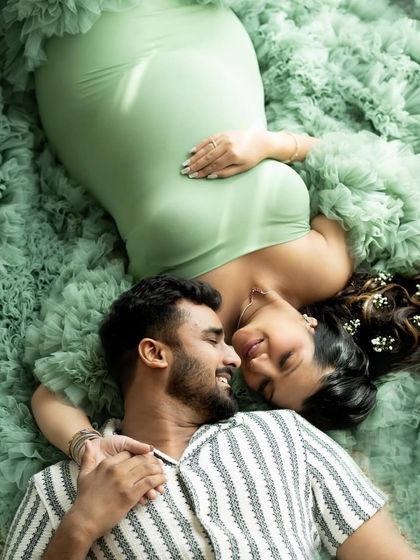 A stunning overhead shot of a couple nestled in a sea of soft green tulle, creating a fairy-tale-like image.